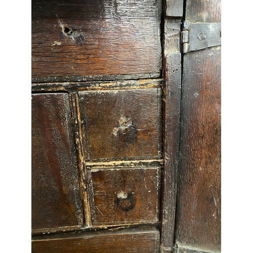 354 - A Charles II oak spice cupboard, the geometric carved door with applied half turned decoration, open... 