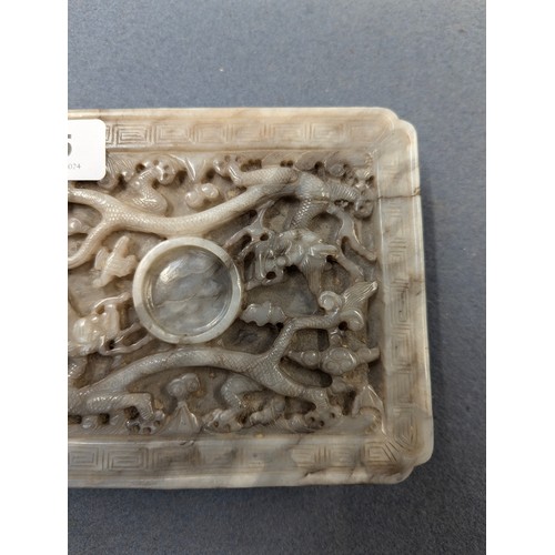 205 - A Chinese grey jade cup stand, of rectangular panel form with canted corners, intricately carved in ... 