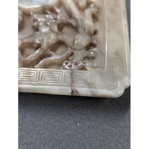 205 - A Chinese grey jade cup stand, of rectangular panel form with canted corners, intricately carved in ... 