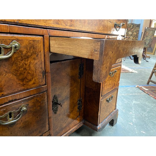 365 - An 18th century walnut kneehole dressing table, the quarter veneered feather banded top over seven d... 