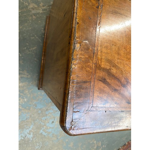 365 - An 18th century walnut kneehole dressing table, the quarter veneered feather banded top over seven d... 