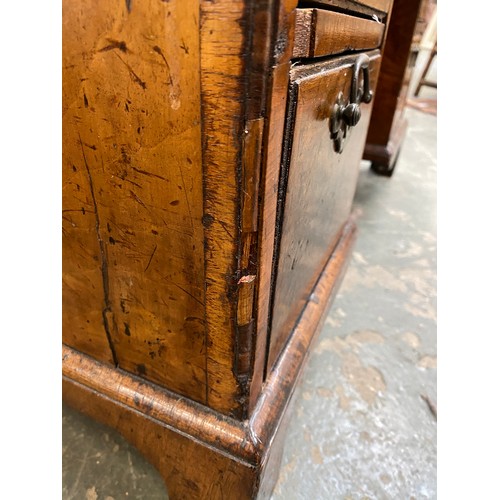 365 - An 18th century walnut kneehole dressing table, the quarter veneered feather banded top over seven d... 