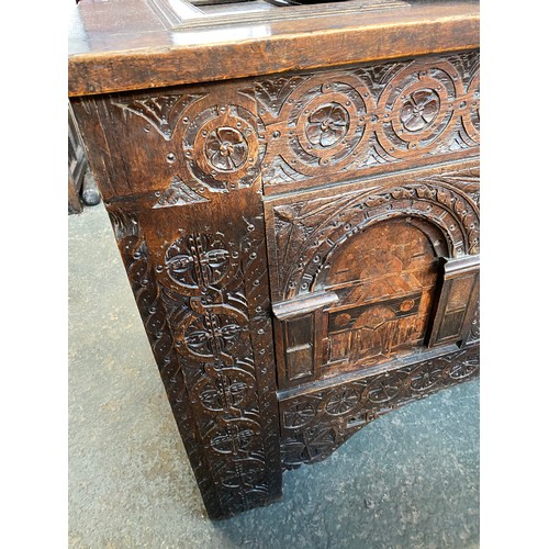 358 - A large 18th century Continental carved oak coffer, the four panel top over a profusely carved three... 