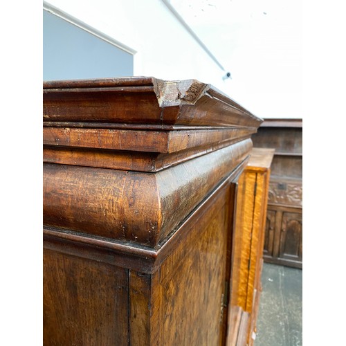 363 - An early 18th century walnut veneer cabinet on chest, the moulded cornice above a cushion frieze dra... 