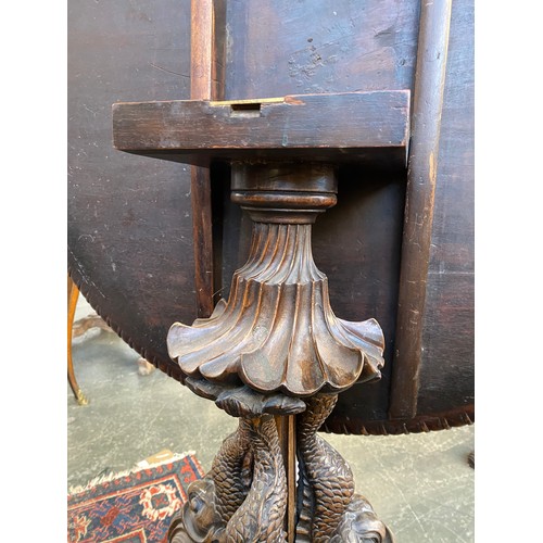 393 - An 18th century tripod table, the dished moulded top raised on a handsomely carved support formed as... 