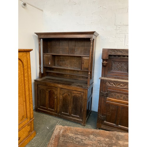 361 - An 18th century oak dresser, the rack with moulded pediment over three shelves and two cupboards, fl... 