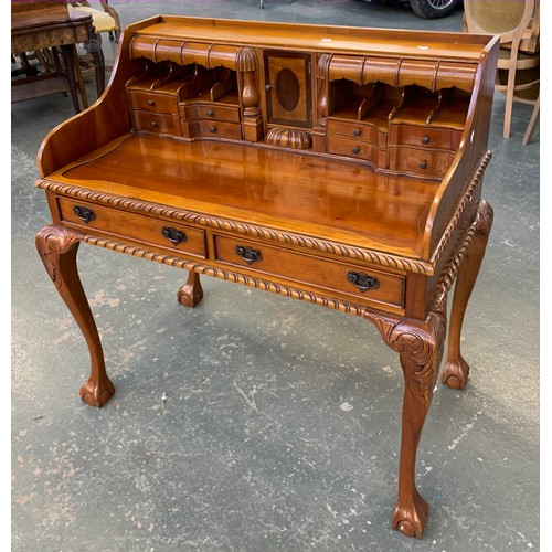 863 - A 20th century hardwood desk with an arrangement of drawers and pigeonholes, over two drawers, on ca... 