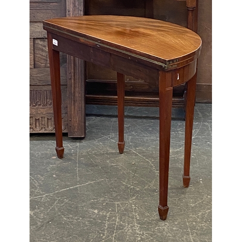 946 - A George III demilune mahogany and boxwood strung card table on square tapered legs and spade feet, ... 