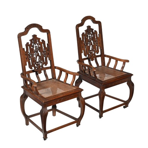 A pair of Vietnamese carved wood armchairs, c.1900, each with cane seat 97cm high