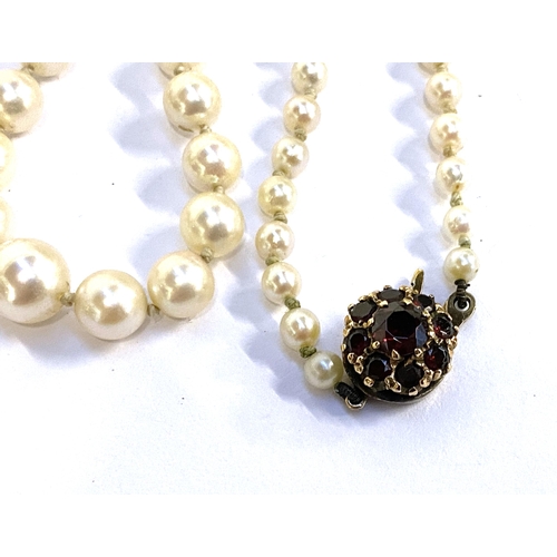 23 - A cultured pearl necklace interspersed with gold and lapis lazuli beads, fastening with a 14k clasp;... 