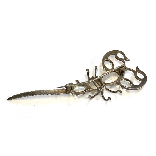 8 - An early 20th century white metal scorpion brooch set with moonstones and ruby eyes, 7cmL, 8.6g