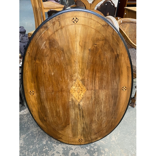 1149 - A Victorian walnut oval tilt top table, quarter veneered top with central marquetry, 115x85x69cmH