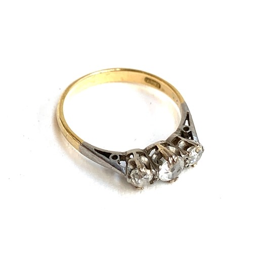 21 - An 18ct gold trilogy ring, set with two diamonds and a central paste replacement stone, size L, 2g