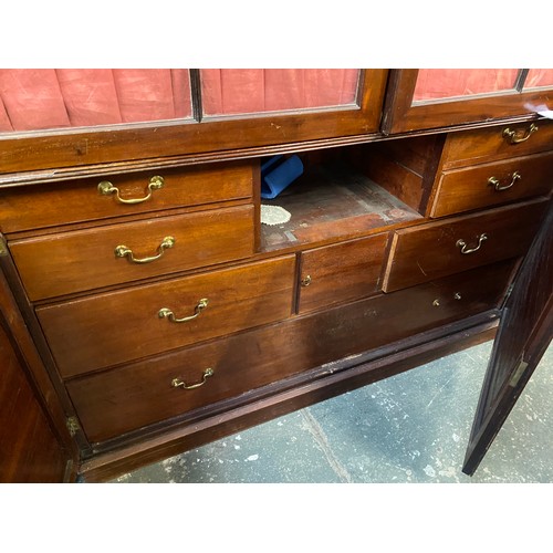 1142 - A George III mahogany and pine press cupboard, probably early 19th century, with a shallow pediment ... 