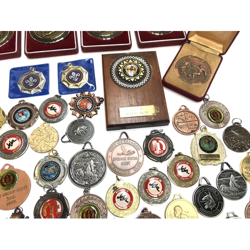 247 - A quantity of swimming and football medals, some in fitted cases