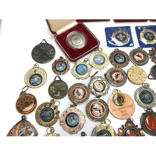 247 - A quantity of swimming and football medals, some in fitted cases