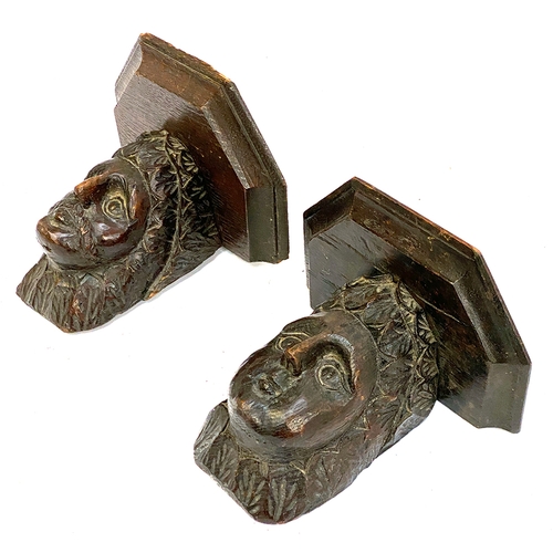 304 - Two carved oak wall brackets in the form of human masks, 21cmW