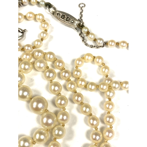 10 - An early 20th century string of cultured pearls, fastening with a silver and marcasite clasp, 51cmL ... 