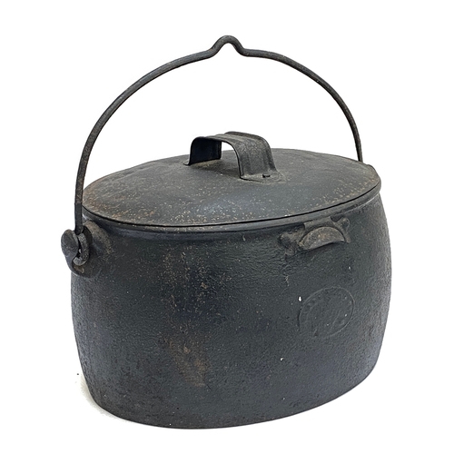 311 - A cast iron lidded pot, 39cmW; with trivet and iron