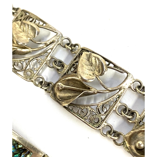 21 - A Mexican silver panel bracelet inlaid with abalone; together with a sterling silver filigree bracel... 