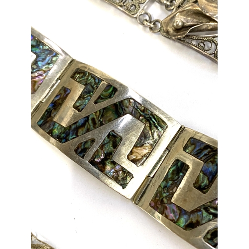 21 - A Mexican silver panel bracelet inlaid with abalone; together with a sterling silver filigree bracel... 