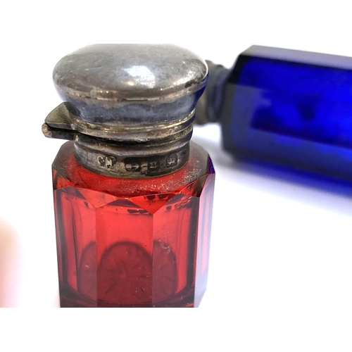 63 - A small silver mounted ruby glass dressing table scent bottle, 4.3cmH; together with a blue glass do... 