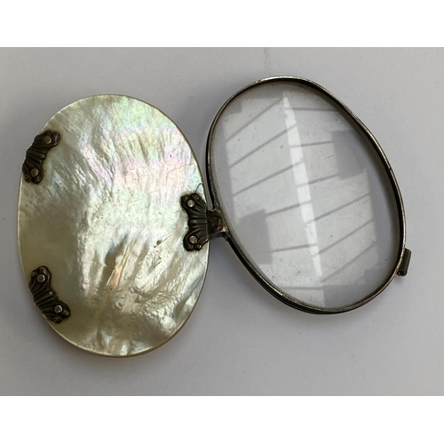 64 - An early 19th century white metal and mother of pearl sliding magnifying glass, 6.5cmW