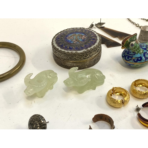 5 - A mixed lot of jewellery to include white metal tribal style earrings; carved jade type buffalo figu... 