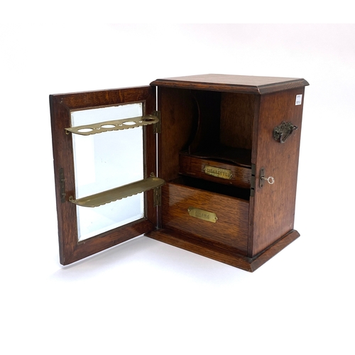 281 - A late Victorian oak and glazed smoker's cabinet, the locking door opening to drawers and brass fitt... 