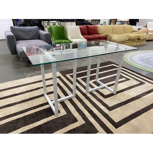 917 - A contemporary glass table on two grey painted supports, 143x70x75.5cmH