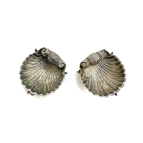 76 - A pair of Victorian silver shell shaped salts on dolphin supports, hallmarked for George Unite, Birm... 