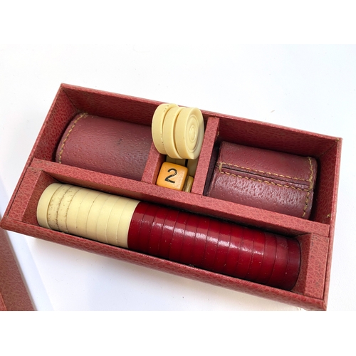 358 - A vintage backgammon set with pieces in a red leather style canvas case, 43cm wide when closed