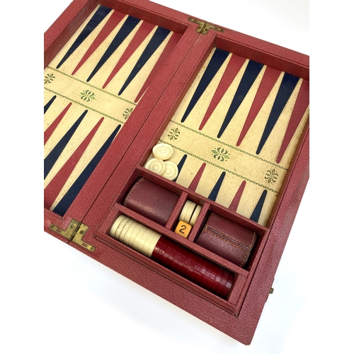 358 - A vintage backgammon set with pieces in a red leather style canvas case, 43cm wide when closed