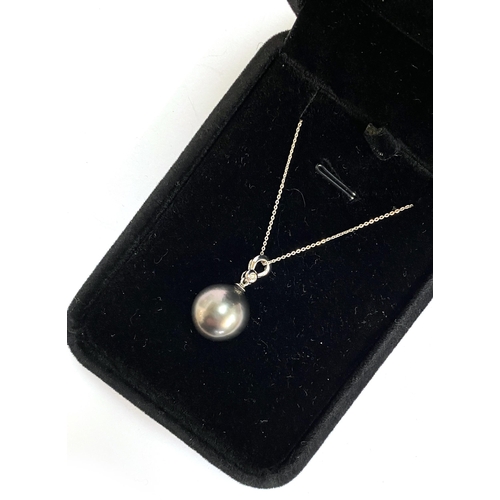 48 - A 18ct white gold mounted black Tahitian pearl pendant, the bail set with a small diamond, the pearl... 