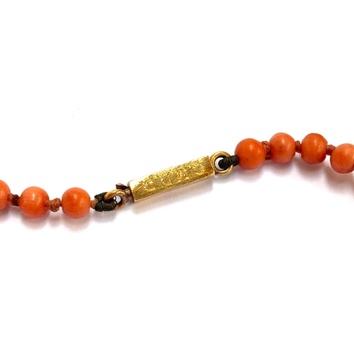 69 - A Victorian coral bead necklace, fastening with a gold clasp engraved 'G.E.D C.M.D.R', the beads app... 