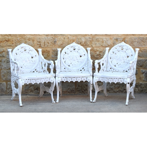 569 - A set of three very heavy white painted cast iron garden chairs, in the manner of Coalbrookdale, the... 