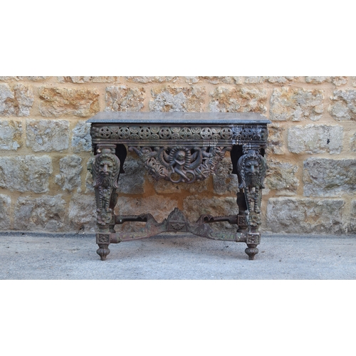 575 - A very heavy 'Four Seasons' cast iron garden table, the rectangular moulded granite top over a pierc... 