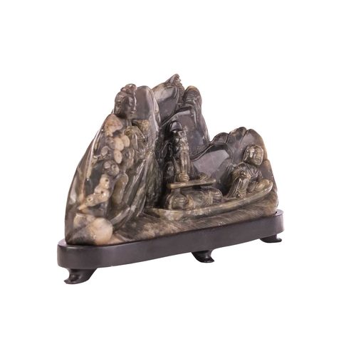652 - A Chinese carved hardstone boulder group of Lu Dongbin surrounded by attendants, a pagoda in a mount... 