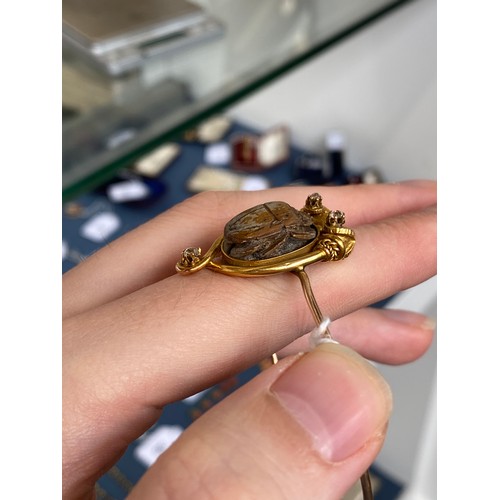 42 - A Victorian archaeological revival bangle, faience scarab mounted in high carat gold in the form of ... 