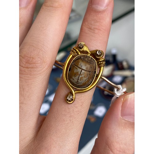42 - A Victorian archaeological revival bangle, faience scarab mounted in high carat gold in the form of ... 