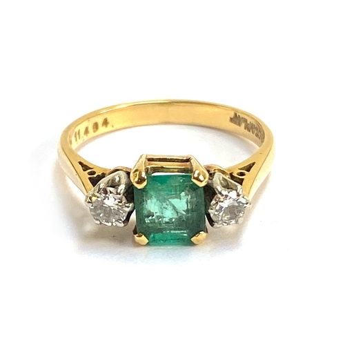 An 18ct gold and platinum ring set with an emerald flanked by diamonds, the emerald 5.9x5.5x3mm and weighing approx. 0.6cts, size M 1/2, approx. 3.6g