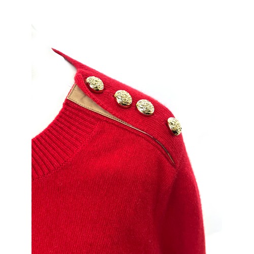 1949 - A Burberry red cashmere knitted women's jumper with gold buttons detailing on shoulder and cuffs, ri... 