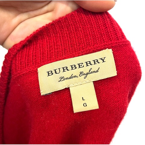 1949 - A Burberry red cashmere knitted women's jumper with gold buttons detailing on shoulder and cuffs, ri... 