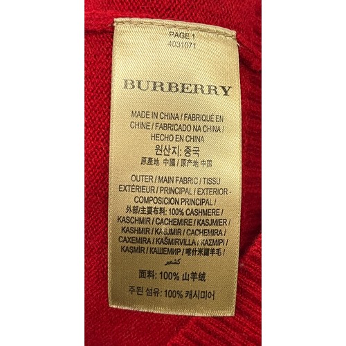 1949 - A Burberry red cashmere knitted women's jumper with gold buttons detailing on shoulder and cuffs, ri... 