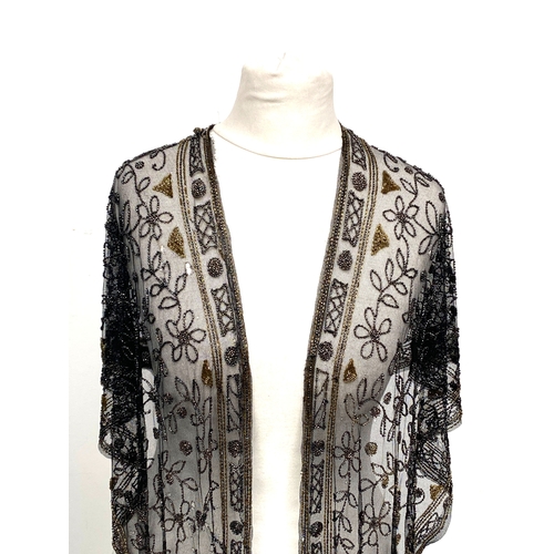 1948 - A 1920s beaded lace shawl, with gold and silver metallic beads in foliate and floral patterns with g... 