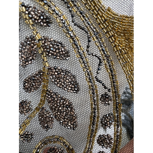 1948 - A 1920s beaded lace shawl, with gold and silver metallic beads in foliate and floral patterns with g... 
