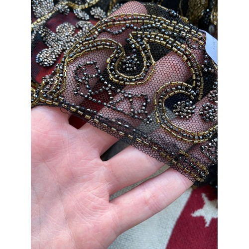 1948 - A 1920s beaded lace shawl, with gold and silver metallic beads in foliate and floral patterns with g... 