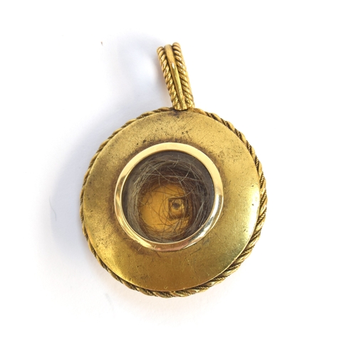 54 - A Victorian yellow metal Etruscan revival pendant with white enamel detail set with a central panel ... 