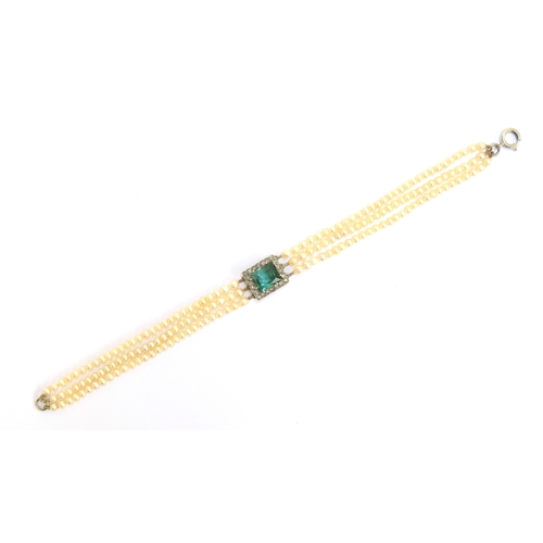 33 - An Edwardian three strand seed pearl bracelet with central rectangular bluish-green tourmaline surro... 