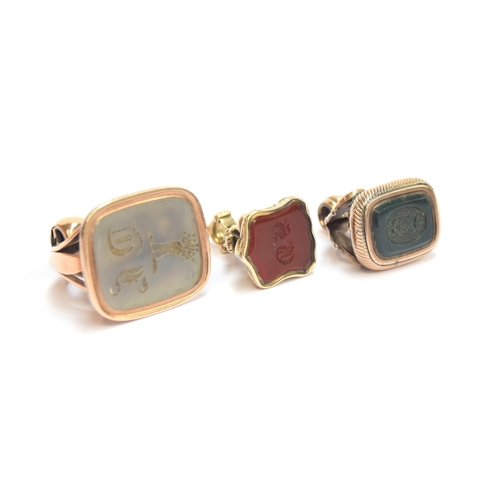 57 - Three Georgian gold cased fob seals, the largest with chalcedony intaglio engraved with a crest of a... 